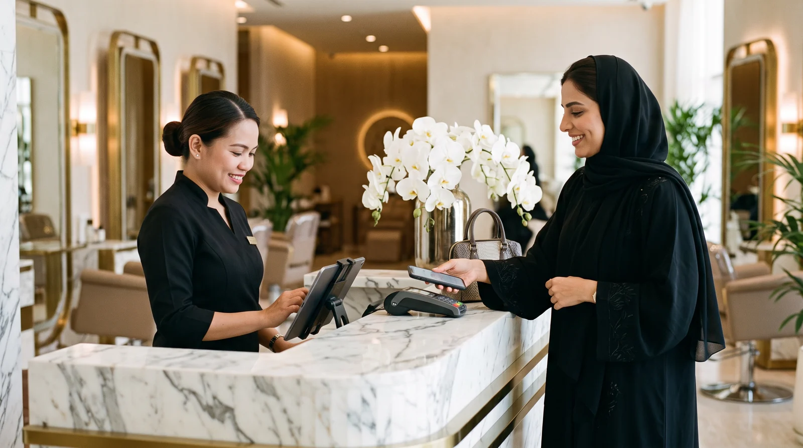 Salon receptionist billing a client on DINGG while the client pays by phone at the front desk