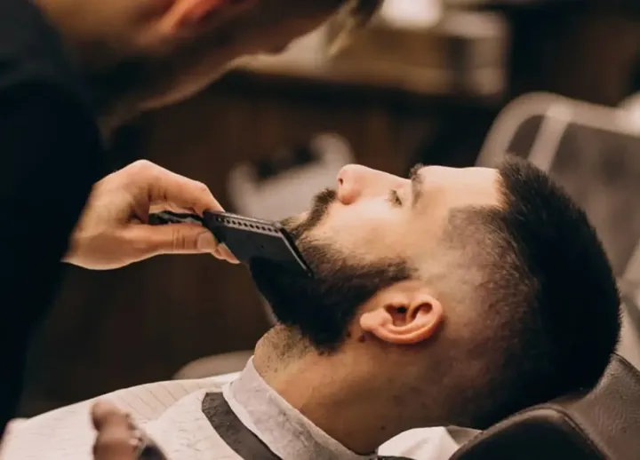 Barber trimming a client's beard