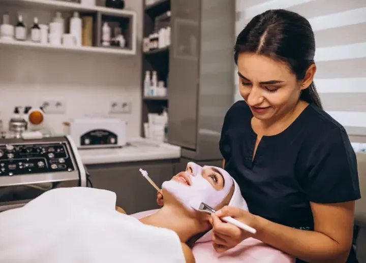 Beautician applying a face mask in a beauty clinic