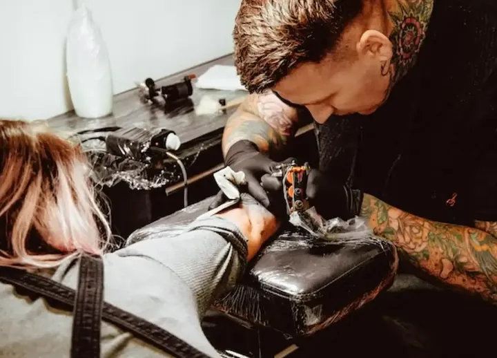 Tattoo artist working on a client